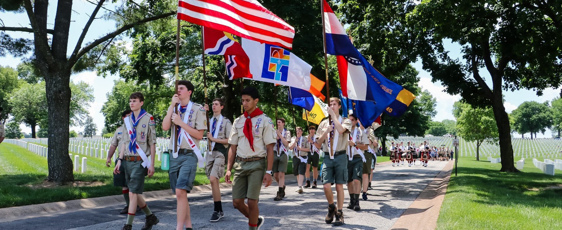 Scouts marching through a cemetary